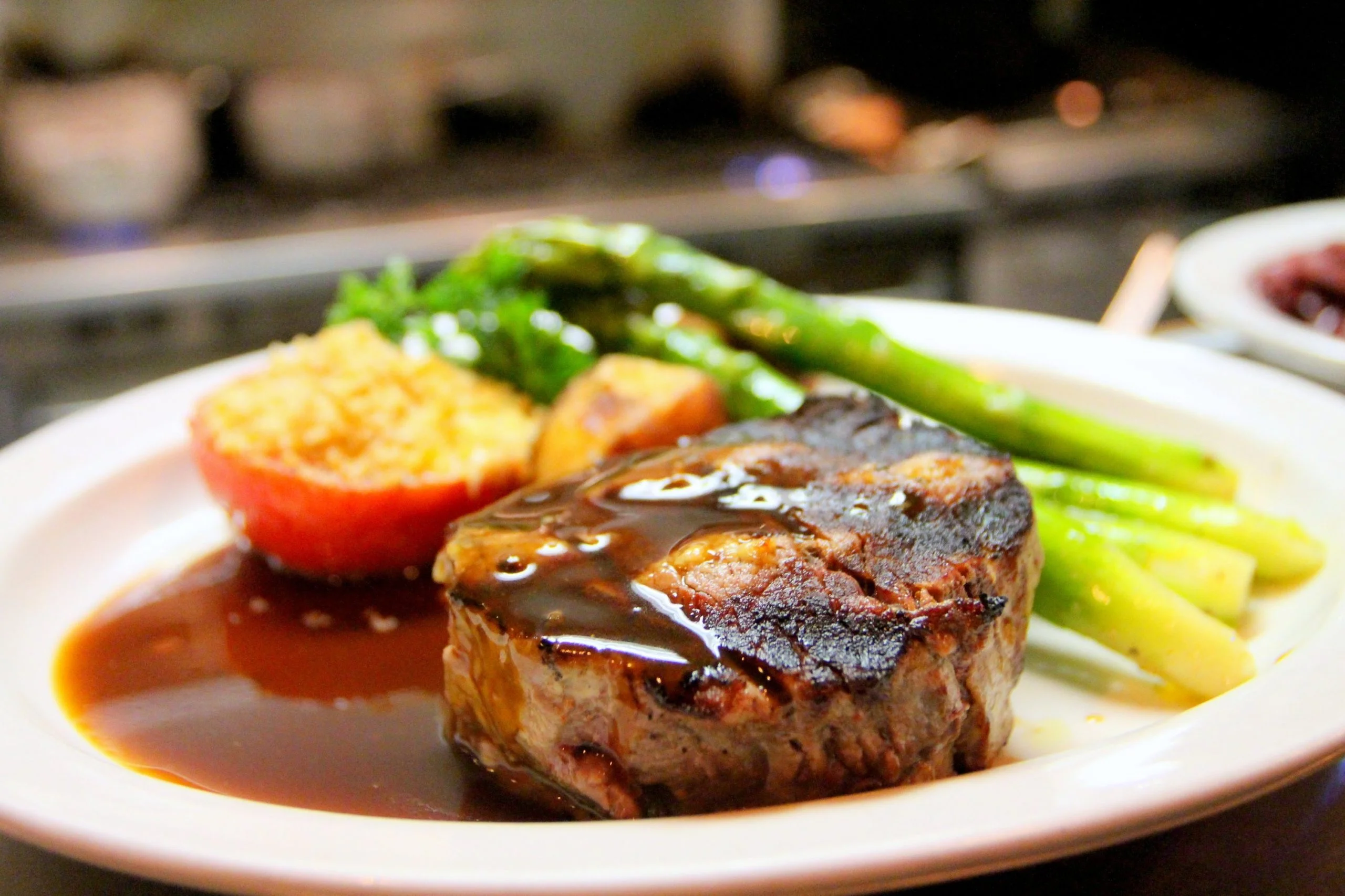 Grilled lamb with rich sauce, asparagus and roasted tomato