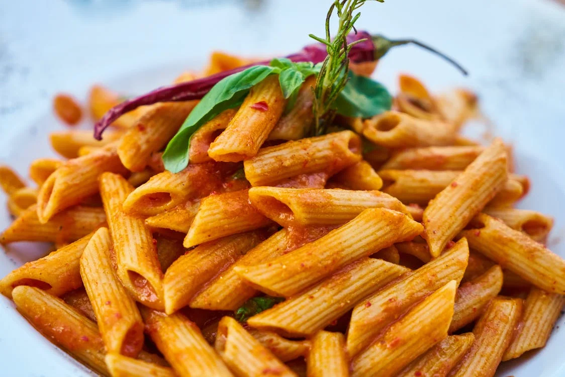 Penne pasta in a rich tomato sauce garnished with fresh basil