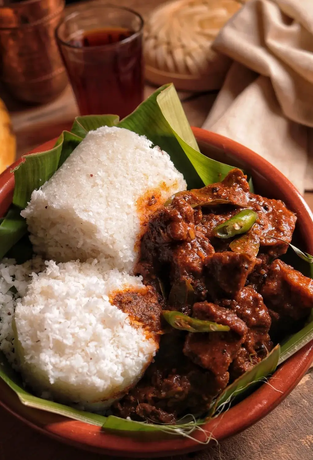 Spiced meat curry served with traditional maize meal and green chilli