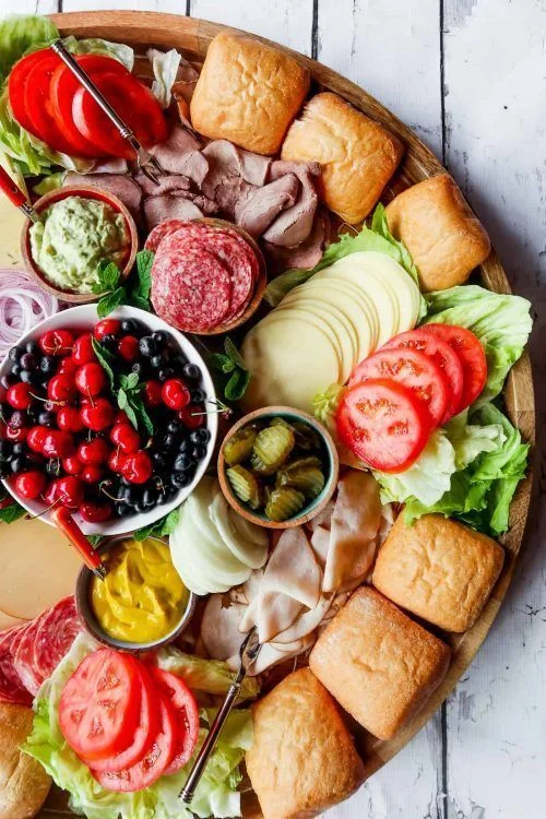 Grazing platter with assorted cold meats, cheese, bread rolls and fresh salad ingredients